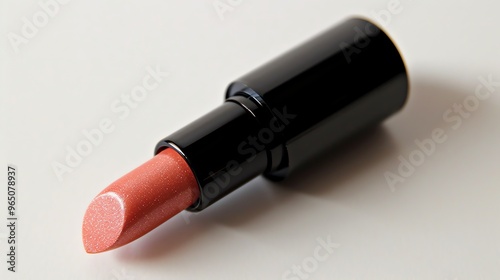 A close up of a coral colored lipstick.