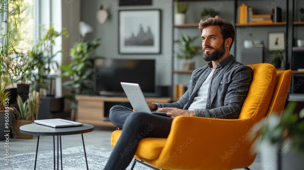 Man working from home in a comfortable armchair with a laptop Man working from home in a comfortable armchair with a laptop