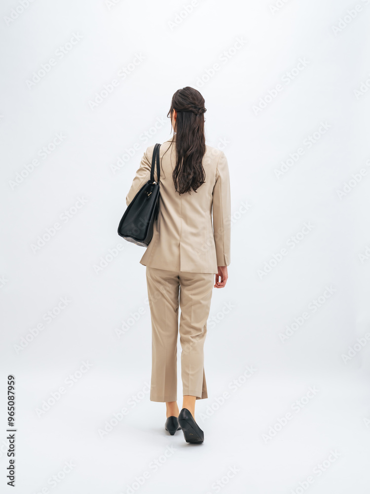 歩く女性ビジネスパーソンの後ろ姿の全身写真 歩く女性ビジネスパーソンの後ろ姿の全身写真