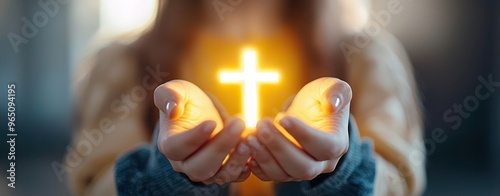 A person holds a glowing cross, symbolizing faith and hope, showcasing spirituality and devotion in a serene environment. photo