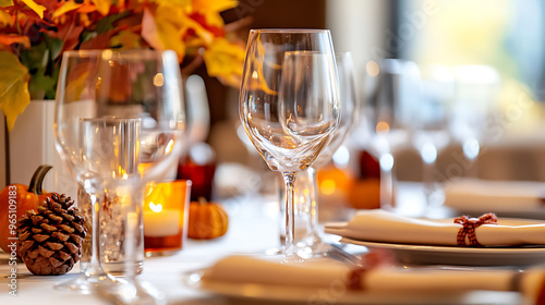 A formal Thanksgiving dinner table arranged with wine glasses, folded napkins, and fall-themed candleholders 