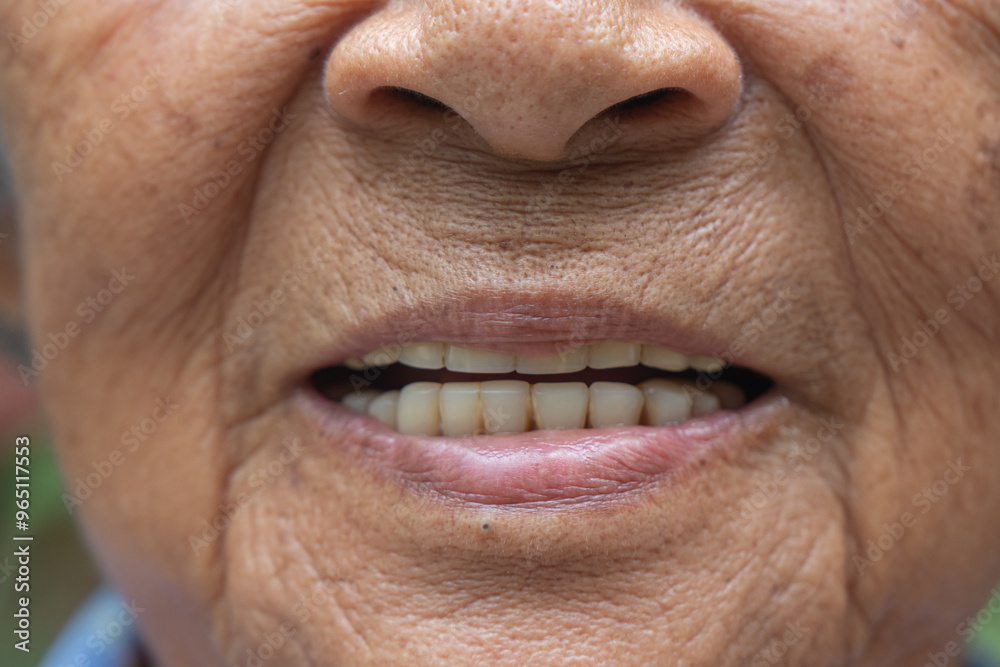 Obraz premium An old Asian woman is smiling with only her mouth.