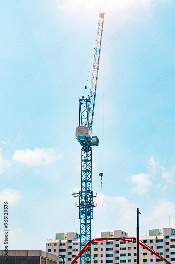 Equipment for the construction and lifting of bulky goods with construction materials. The tower crane is attached to the boom with a load secured with steel cables. Construction equipment. Equipment for the construction and lifting of bulky goods with construction materials. The tower crane is attached to the boom with a load secured with steel cables. Construction equipment.