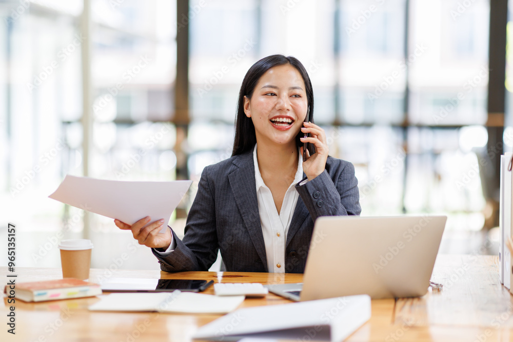 Business Asian woman freelancer is working her job on a laptop computer and phone call in the office. Doing accounting analysis report real estate investment data, Financial and tax systems concept. Business Asian woman freelancer is working her job on a laptop computer and phone call in the office. Doing accounting analysis report real estate investment data, Financial and tax systems concept.
