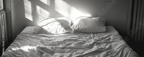 An unmade bed with a single pillow left undisturbed, loss, the absence of companionship photo