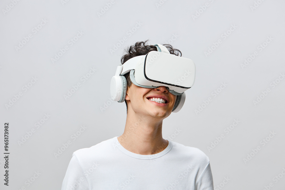 Virtual reality experience, smiling young man wearing VR headset and headphones, enjoying immersive technology, modern and minimalist background, focused on digital adventures