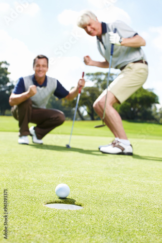 Ball, hole and excited men on golf course together for teamwork, outdoor fun and fitness competition at club. Sports, senior father and son on green for partnership, bonding and support for hobby.