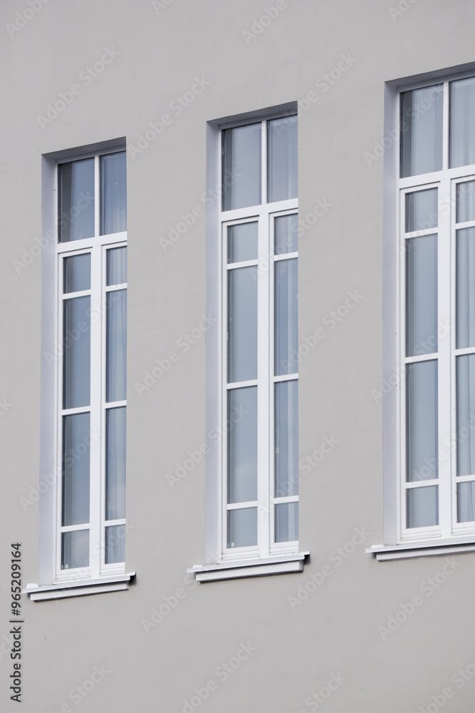 Three windows on a building with a white frame Three windows on a building with a white frame