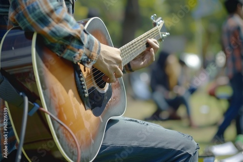 Close up Young man playing guitar with friends attend a live music event concert in a park