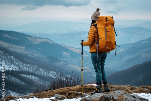 back view hiker fully equiped standing on the mountain top and enjoys the panoramic landscape copy space