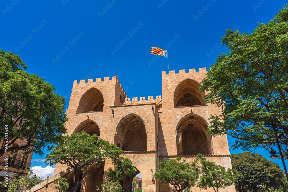 Fototapeta premium Valencia, Spain. Rear view of the Torres de Serranos, an old gate on the city's walls with a Regional Valencian Flag on top of them