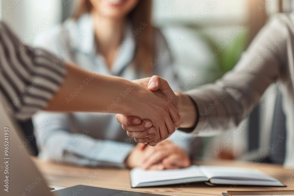 Happy bank manager shaking hands with a client after successful agreement in the office Happy bank manager shaking hands with a client after successful agreement in the office
