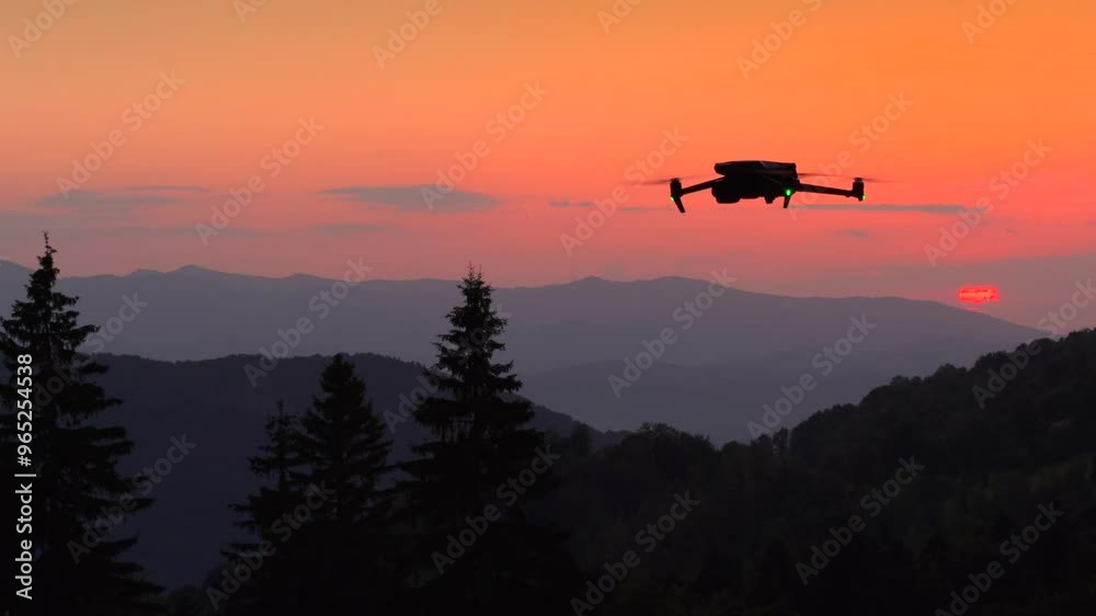 Silhouette of a drone hovering in flight against sunset sky. 4K video with a drone in flight. Silhouette of a drone hovering in flight against sunset sky. 4K video with a drone in flight.