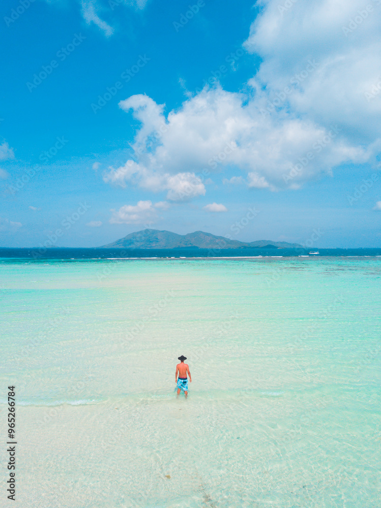 Man walking on tropical white sand beach with turquoise ocean. summer background and summer holiday. Man walking on tropical white sand beach with turquoise ocean. summer background and summer holiday.