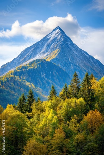 Majestic mountain peak surrounded by vibrant autumn foliage under a clear blue sky