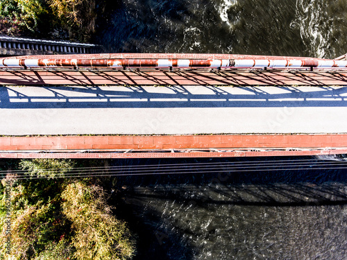 Aerial view of running trail with metal bridge over river. Running training, no people. photo