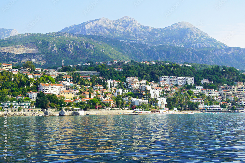 View from the Bay of Kotor to the Savina area in Herceg Novi and the mountain village of Podi. Landscape from the Montenegrin coast: the waters of the sea, Mount Orjen and the city between them. View from the Bay of Kotor to the Savina area in Herceg Novi and the mountain village of Podi. Landscape from the Montenegrin coast: the waters of the sea, Mount Orjen and the city between them.