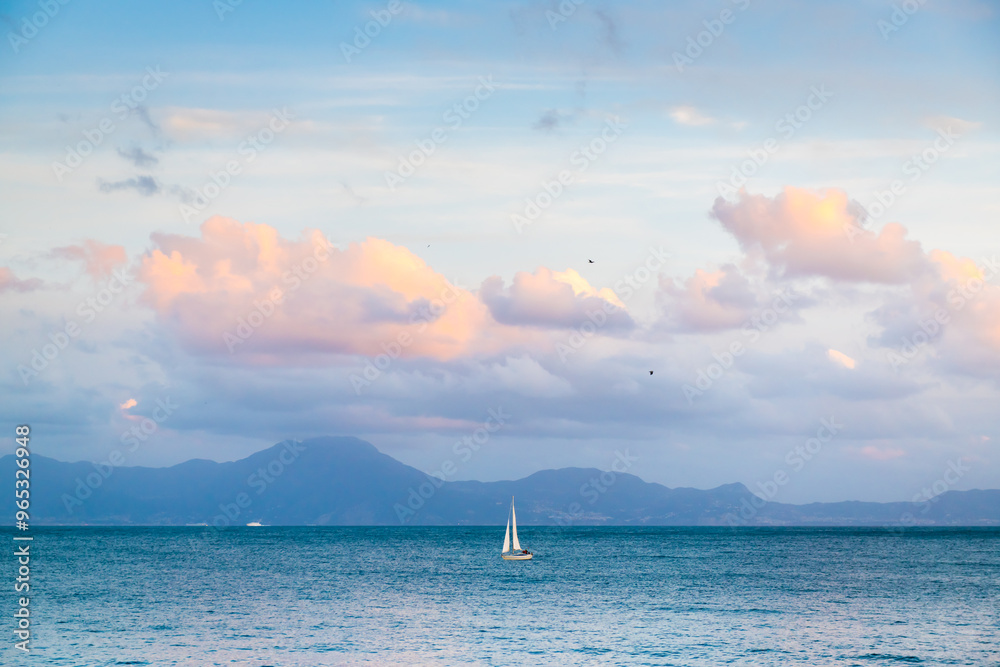 Yacht sailing in Gulf of Naples, Italy. View of the mountains and the sky at sunset.