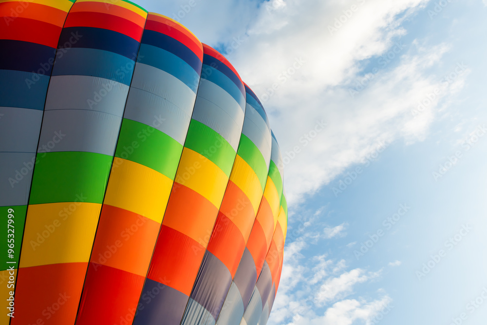 Colorful hot air balloon against the blue sky with white clouds.
