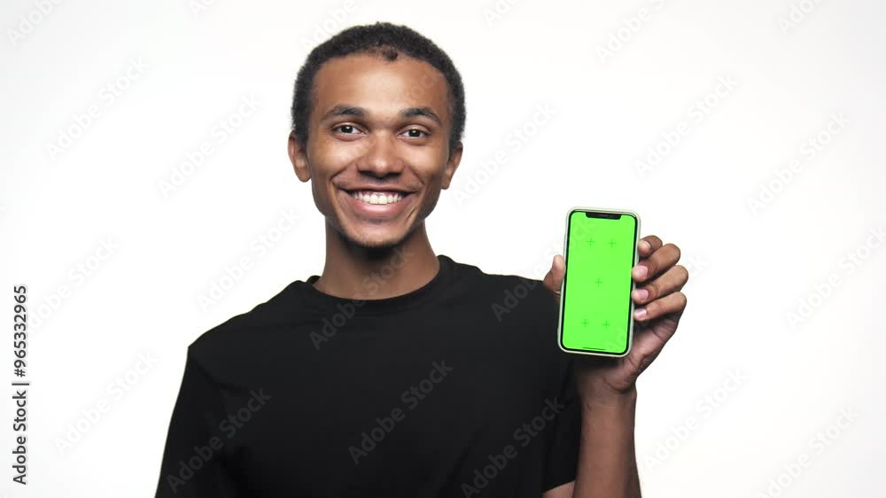 Smiling man pointing at smartphone with chroma key screen Smiling man pointing at smartphone with chroma key screen