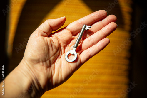 A woman holds an old key in her hand symbolizing genealogy and inheritance.