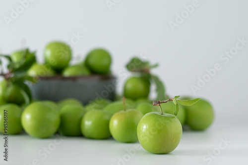 Green plum fruit in ceramic bowl on white background, fruit that pregnant women love