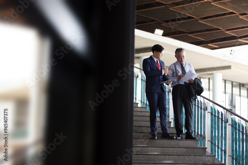 Two Asian businesspeople having a business discussion in the office building.