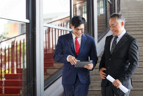 Two Asian businesspeople having a business discussion in the office building.