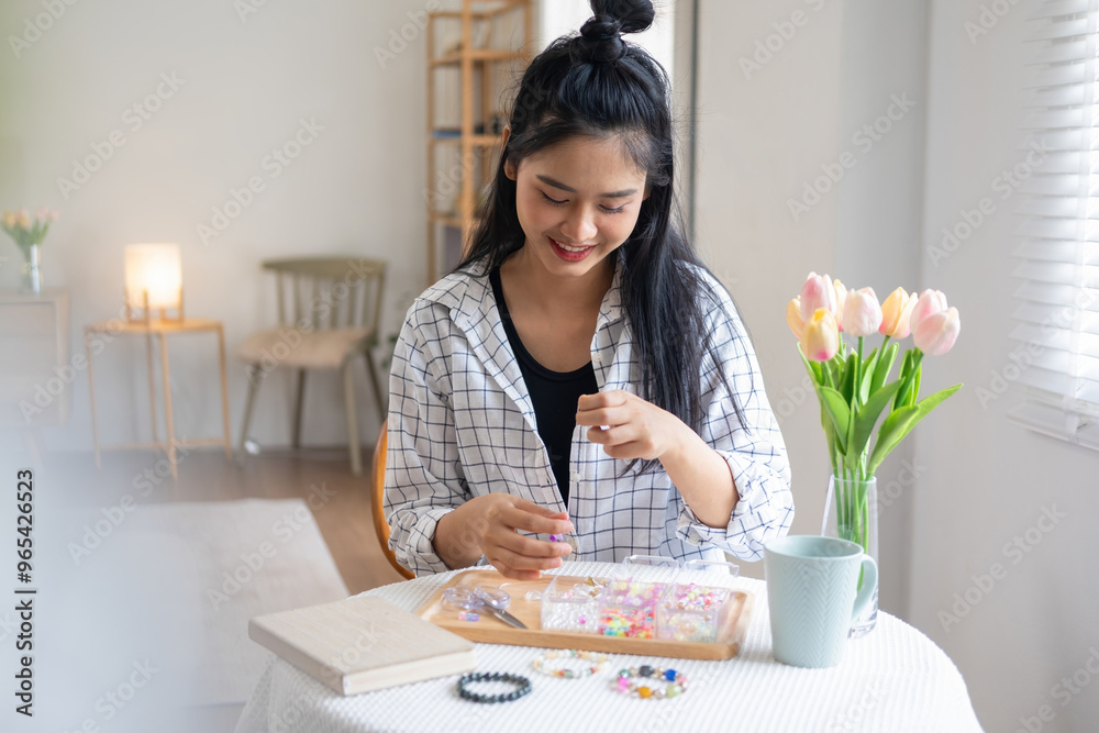 Young girl making handmade bracelets with fun and cheerfulness Young girl making handmade bracelets with fun and cheerfulness