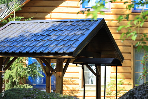 Cozy residential scene with wooden house and a gazebo, suitable for home or family use. photo