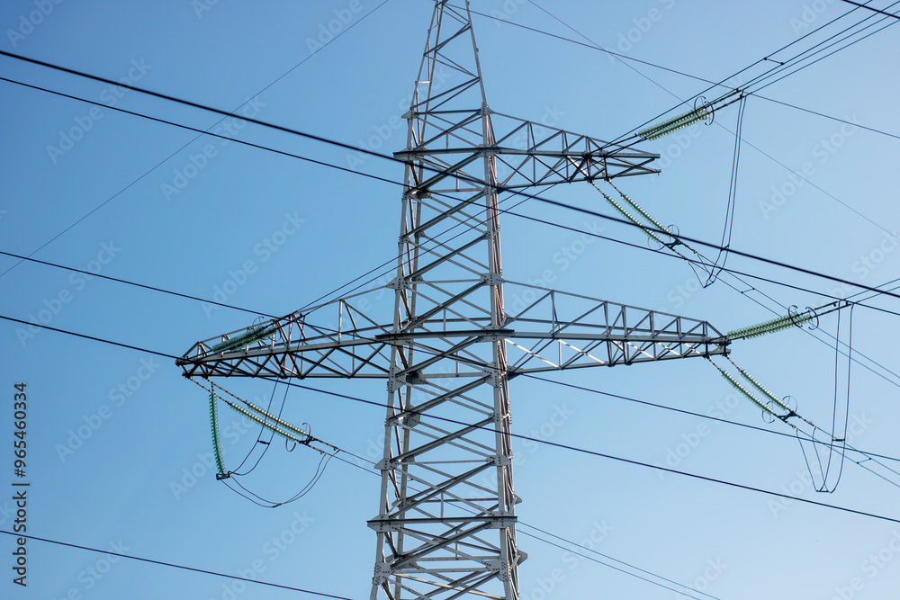 A tall telephone pole standing against a vast blue sky backdrop A tall telephone pole standing against a vast blue sky backdrop