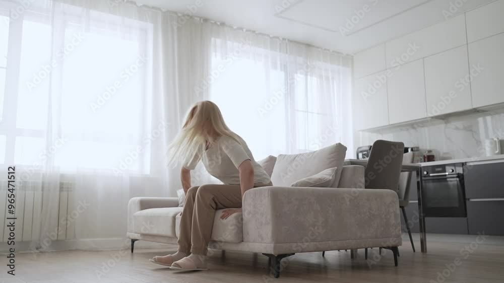 A senior woman is enjoying a peaceful moment while relaxing on a sofa at her home A senior woman is enjoying a peaceful moment while relaxing on a sofa at her home