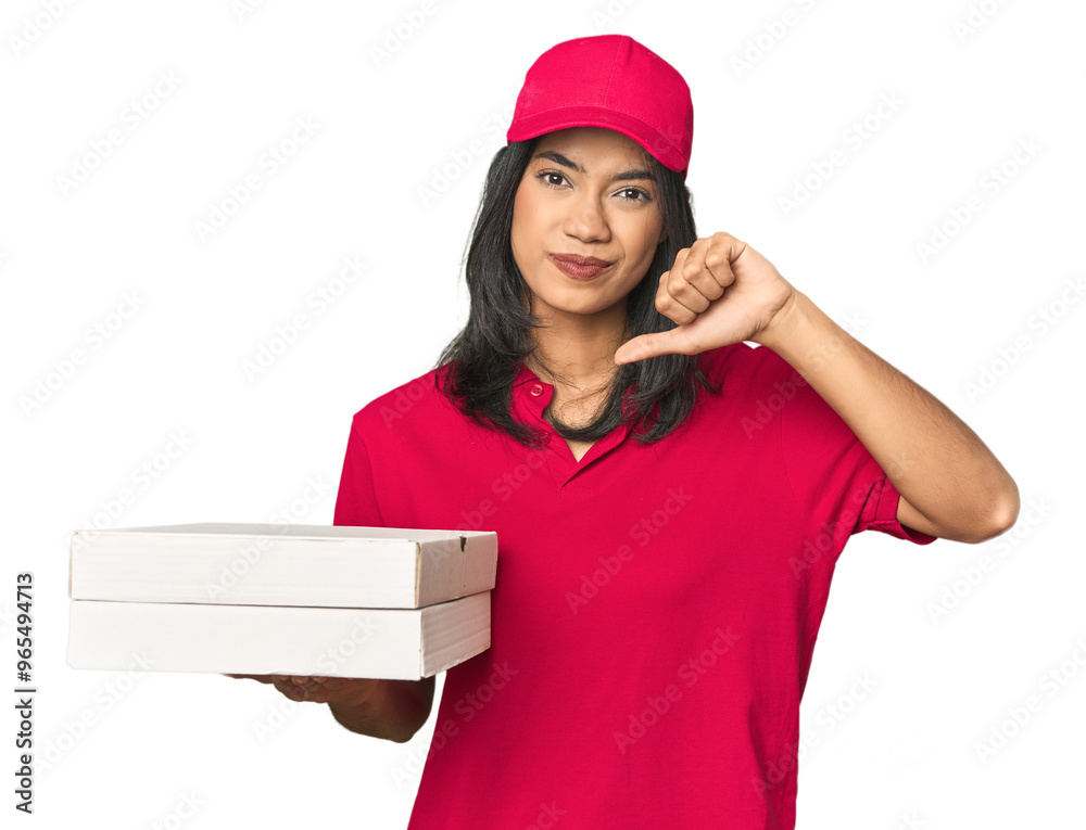 Latina delivering pizza, studio setup showing a dislike gesture, thumbs down. Disagreement concept. Latina delivering pizza, studio setup showing a dislike gesture, thumbs down. Disagreement concept.