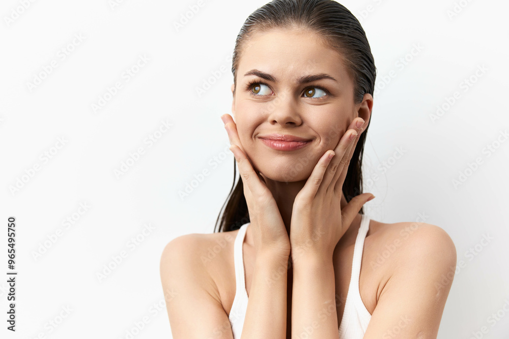 Young woman with a playful expression touching her face, against a clean white background, showcasing beauty and innocence Her glossy hair adds to the fresh, vibrant look Young woman with a playful expression touching her face, against a clean white background, showcasing beauty and innocence Her glossy hair adds to the fresh, vibrant look