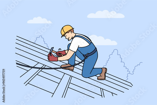Man builder installs shingles on roof of house, using hammer and nails to securely fasten them. Guy, repair and construction specialist, stands on roof, nailing boards to frame of building.
