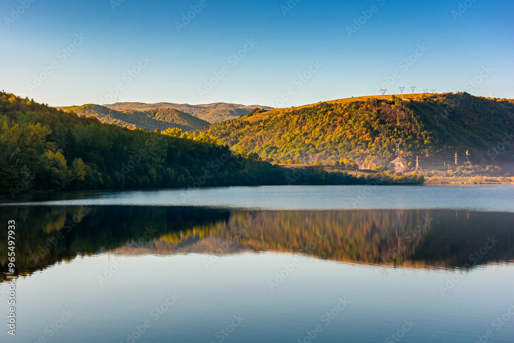 mountain landscape at the lake in autumn. trees in colorful foliage on the shore. beautiful nature view on a sunny morning. scenery reflecting on the rippled water surface mountain landscape at the lake in autumn. trees in colorful foliage on the shore. beautiful nature view on a sunny morning. scenery reflecting on the rippled water surface
