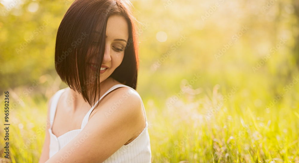 A woman smiles peacefully while enjoying the serene beauty of a sunlit meadow, representing happiness and tranquility in nature. A woman smiles peacefully while enjoying the serene beauty of a sunlit meadow, representing happiness and tranquility in nature.
