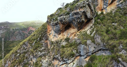 Beautiful shot with drone zoom in to a cave on top of a mountain with vegetation in Millpu located in Ayacucho, Peru. photo