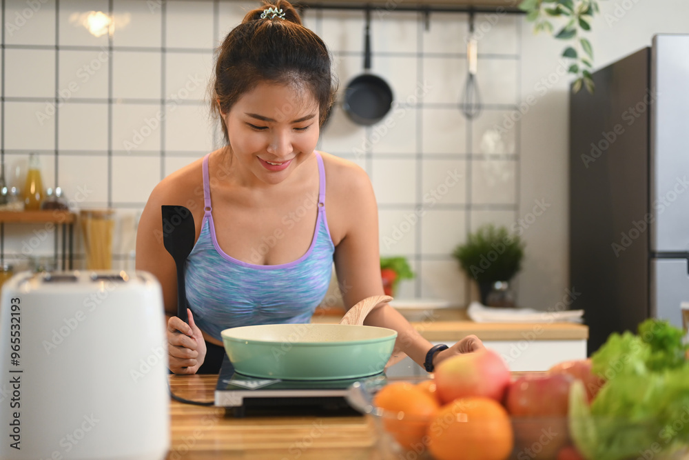 Happy young fitness woman preparing healthy meal on kitchen counter. Healthy lifestyle concept Happy young fitness woman preparing healthy meal on kitchen counter. Healthy lifestyle concept