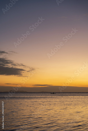 a beautiful sunset with a lone fisherman fishing on a far away sea