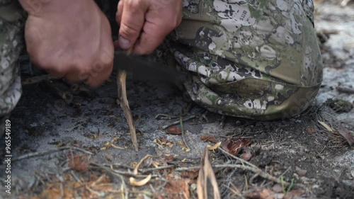 Preparing forest kindling sticks as fire starters for a campfire