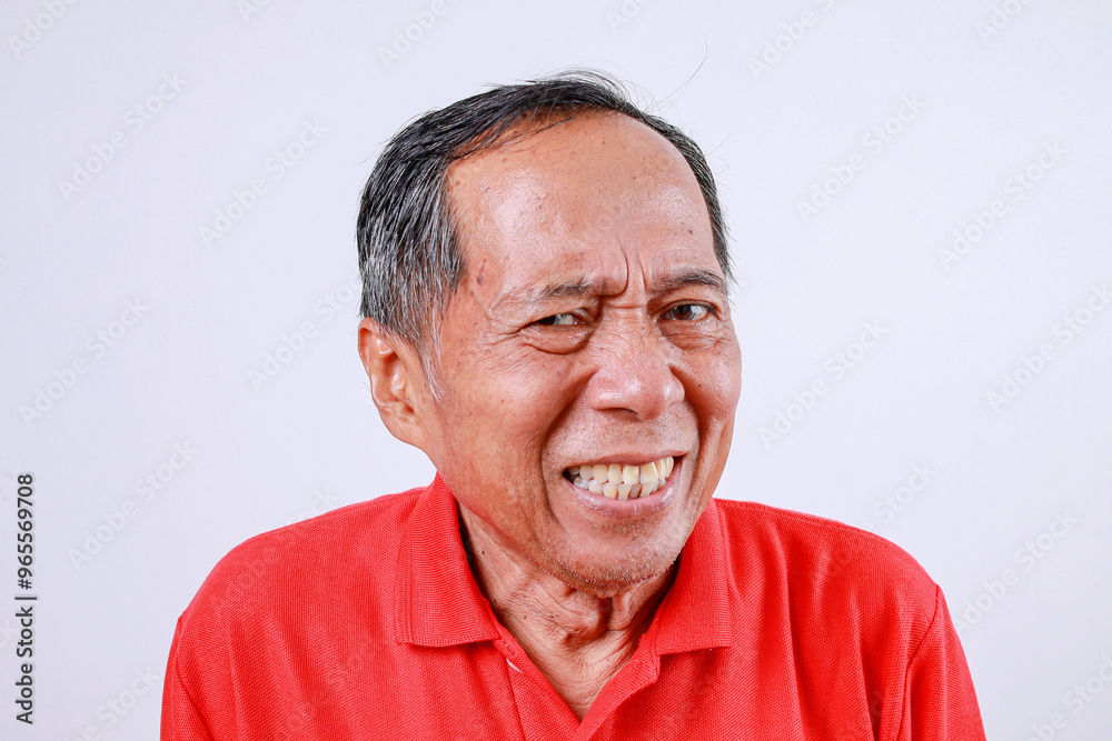 Fototapeta premium Displeased senior Asian man in red t-shirt isolated on white background