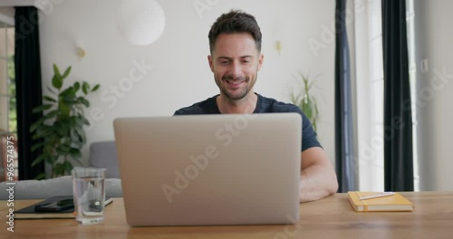 Video of smiling man opening laptop at home sitting at a table