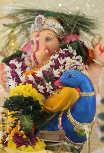 lord ganesha idol on Ganesh chaturthi. little Ganpati is sitting a beautiful peacock in the idol. the temple is decorated with lights and flowers. On the occasion on Ganesh Stapna on chaturthi  photo