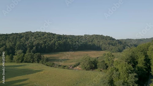 Wallpaper Mural A peaceful countryside scene showcasing a lush green hillside, meadows, and a flowing stream. A serene landscape perfect for nature lovers and rural travel inspiration. Torontodigital.ca