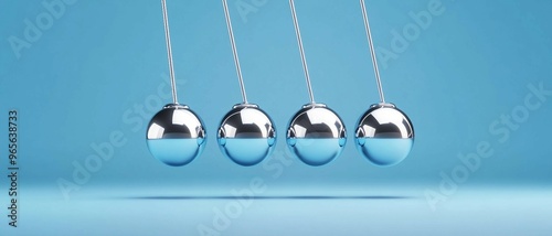 Newton Cradle, silver balls on a blue background. Physics concept, Motion and energy transfer, Balance and equilibrium.