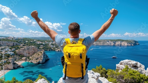 A man celebrates his adventure atop a cliff, overlooking a stunning coastal view with azure waters and beautiful landscapes.