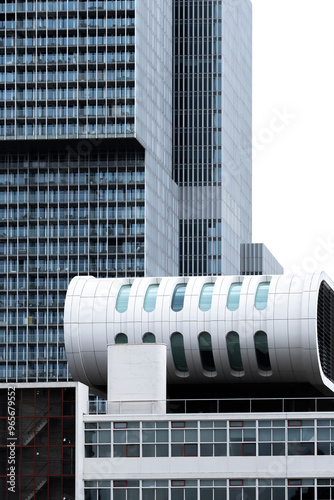 An eye-catching cylindrical white structure stands out among the modern glass and steel skyscrapers, highlighting architectural innovation within the urban landscape in Rotterdam