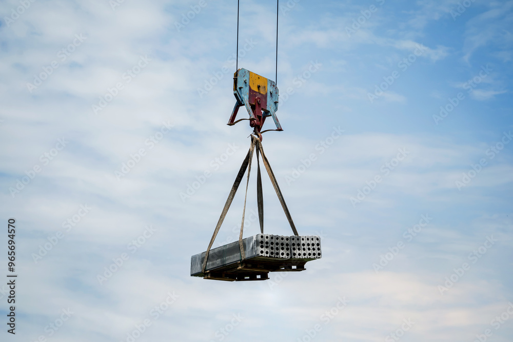 Heavy construction load being lifted by a tall crane Heavy construction load being lifted by a tall crane