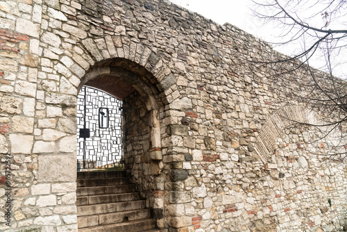 gate to the garden behind the wall of an ancient castle, made of stones